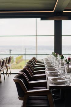 Sophisticated dining area with a view, set with glassware and flowers. Perfect for events.