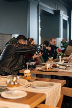 People enjoying a meal in an Istanbul café while capturing photos in a lively atmosphere.