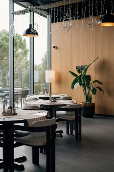 A stylish cafe interior in Istanbul with large windows and green plants.