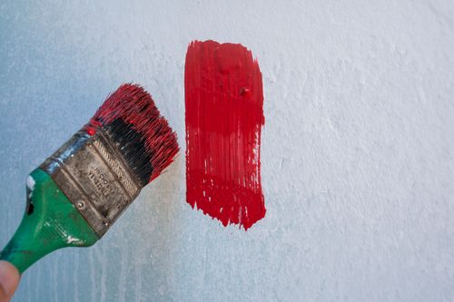Free Close-up of a paintbrush applying red paint on a wall in Mérida, Venezuela. Stock Photo