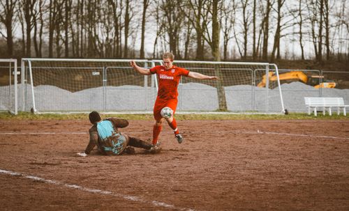 Free Two players compete fiercely in a soccer match on a muddy field. Stock Photo