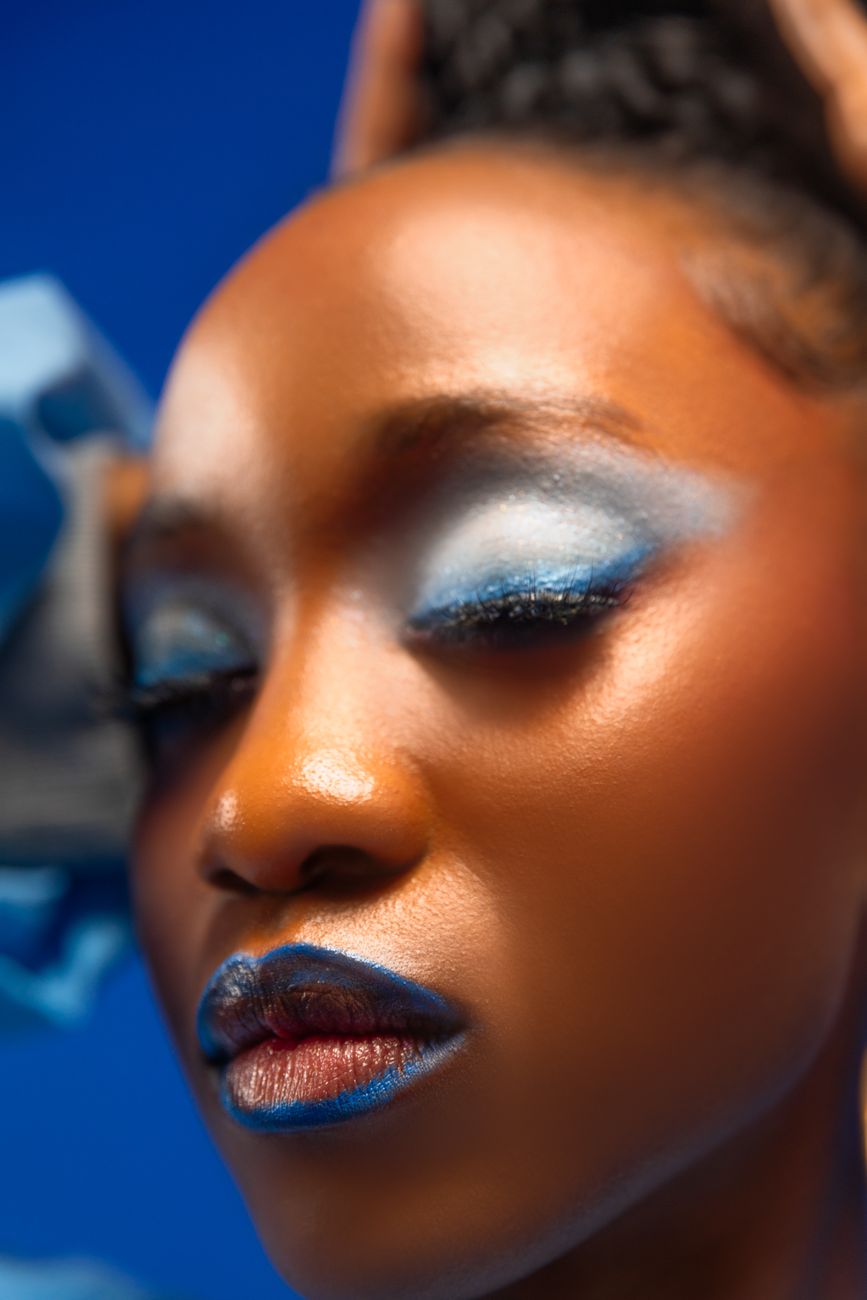 Close portrait with bright blue eye makeup, matching the relaunch's bet on colour and drama.