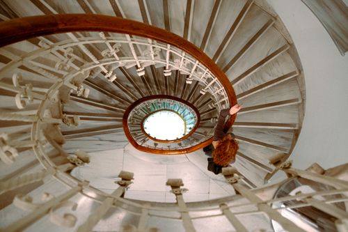 Free Top view of a person on a spiral staircase with intricate railing. Stock Photo
