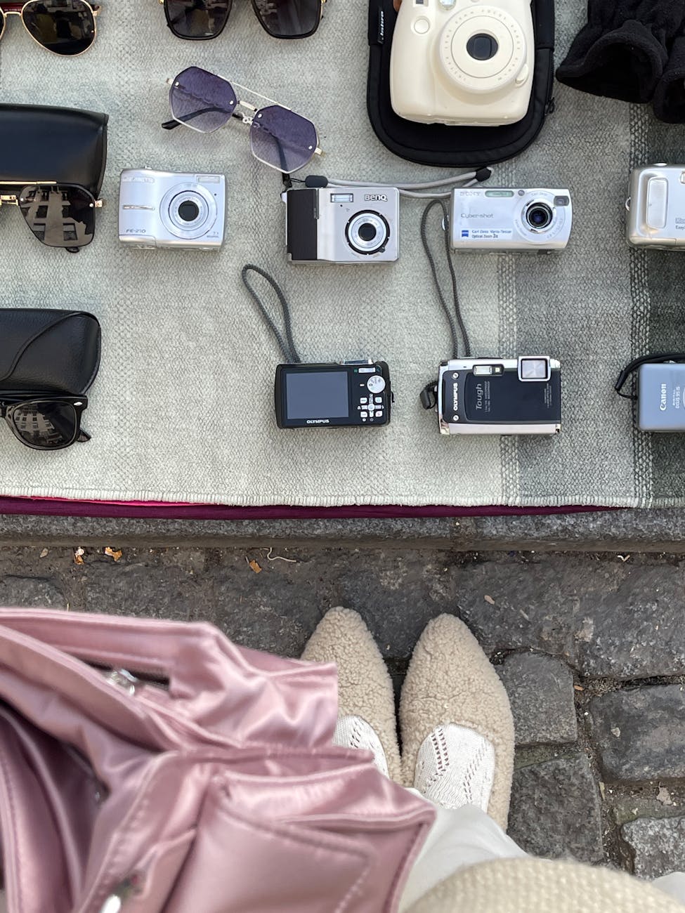 Overhead view of vintage cameras and accessories on display at a street market.