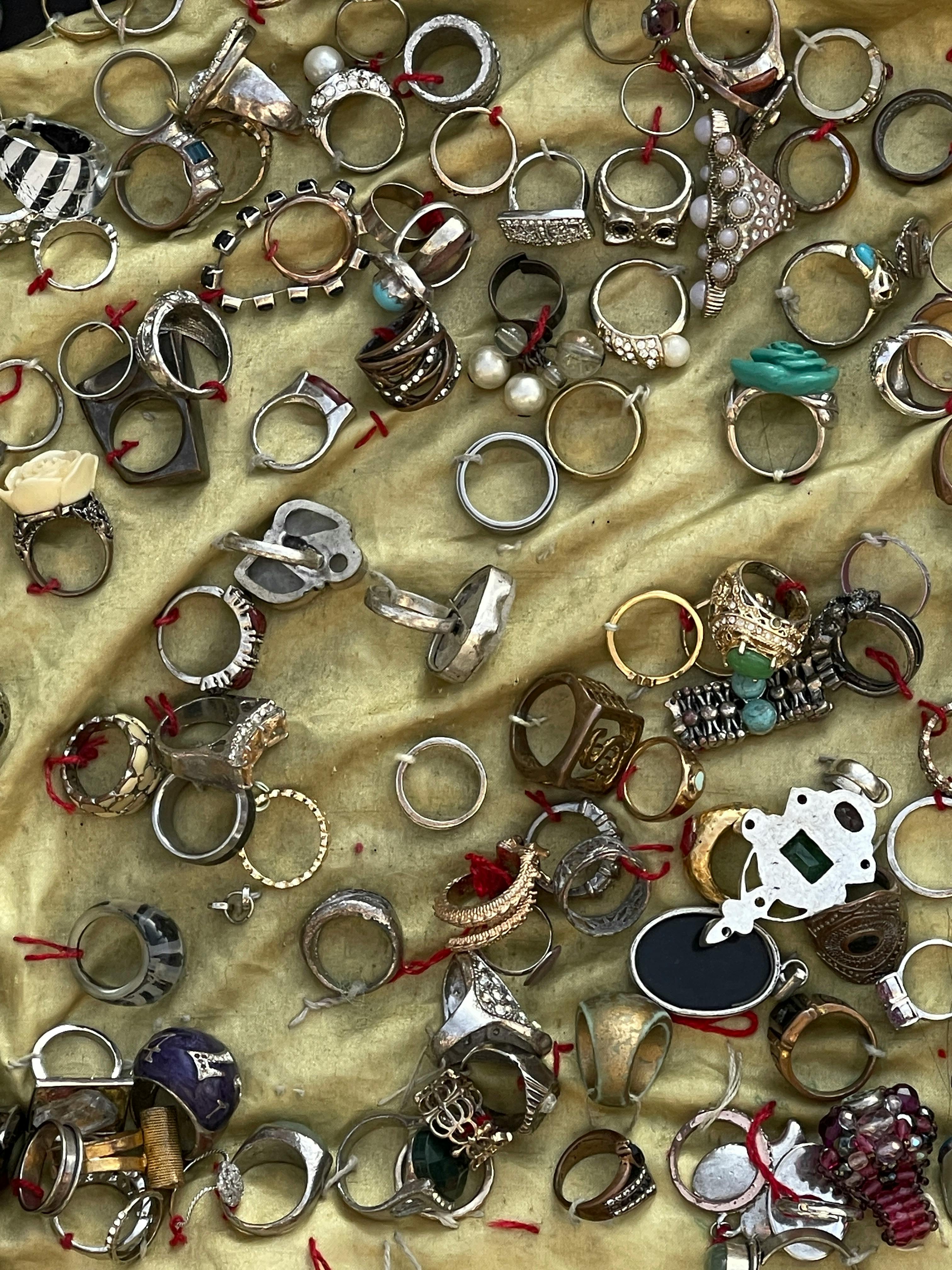 Assorted rings of various designs and materials on a golden background.