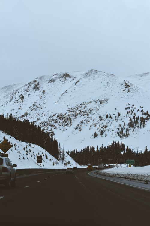 Free A winter scene of a snowy road alongside the Rockies in Aspen, CO. Stock Photo