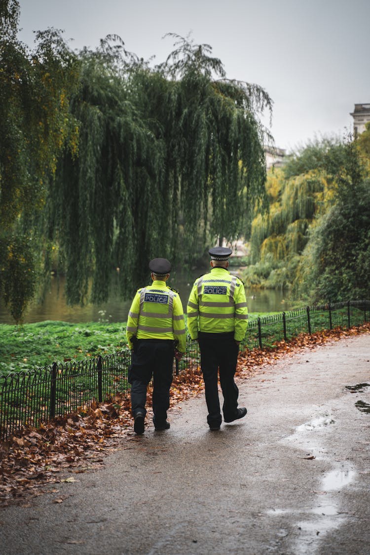 2 Securities Walking Beside Dried Leaves