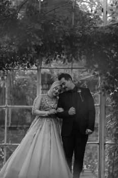 Elegant black and white wedding photo of an embracing couple looking happy.