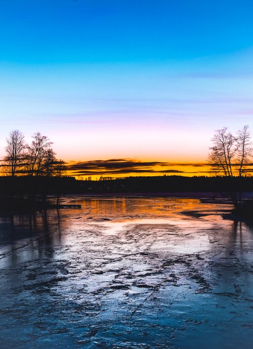 Free Captivating sunset with vibrant colors over a frozen lake in Uddeholm, Sweden. Stock Photo