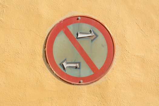 A weathered 'No Left Turn' traffic sign on a bright yellow wall, highlighting urban decay.