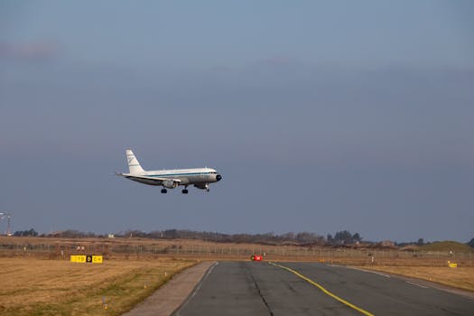 Airplane approaching runway for landing at airport with clear sky background.