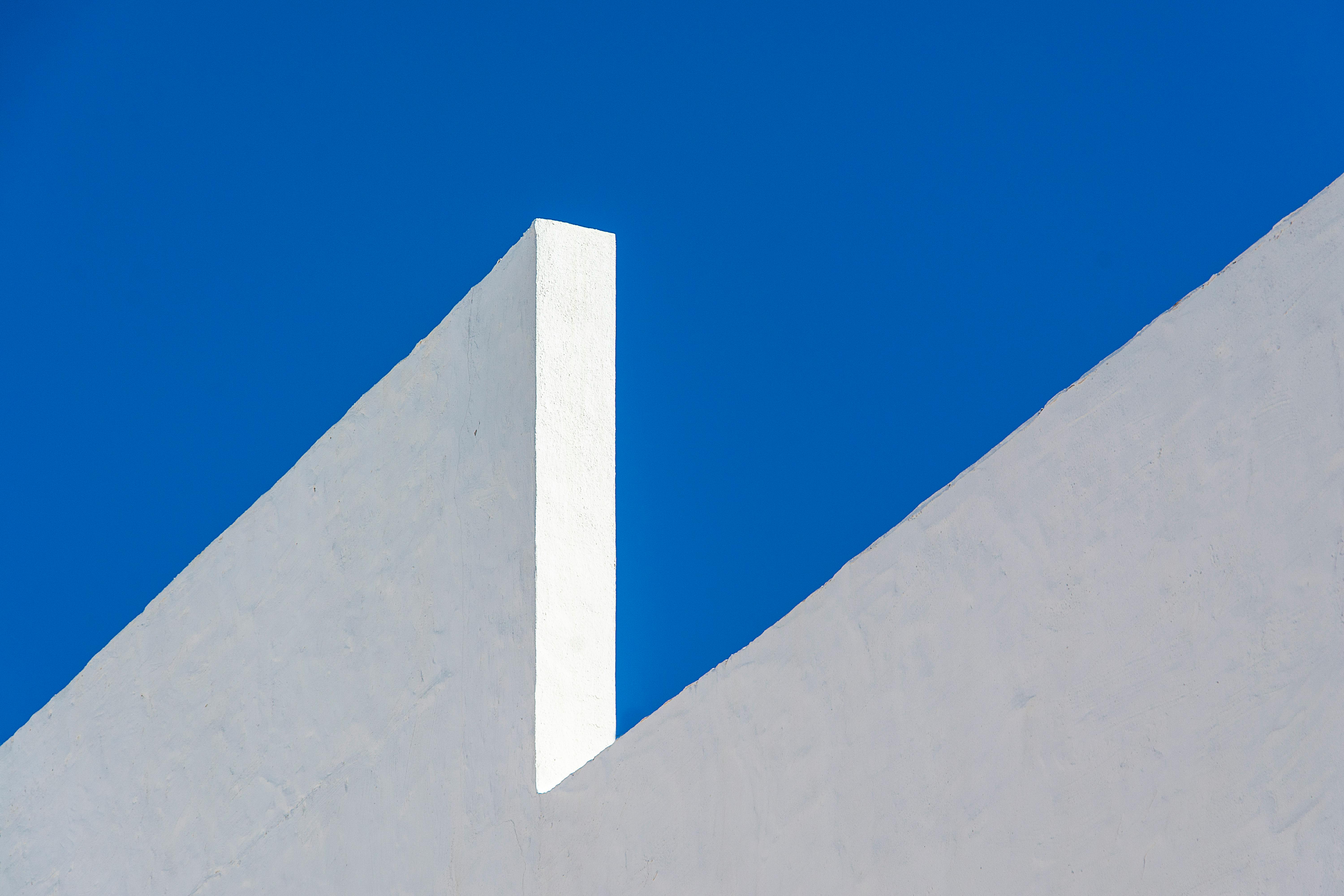 bezplatná Úchvatný minimalistický obraz bílé stěny na pozadí zářivě modré oblohy představující moderní architekturu. Základová fotografie