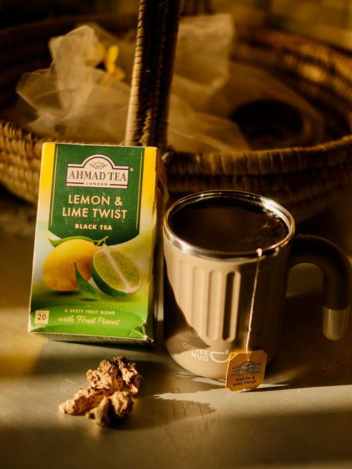 Free Tea box and mug with lemon and lime twist flavor captured in warm indoor light. Stock Photo