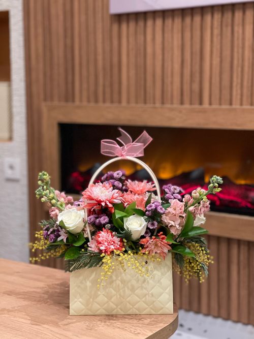 Free Beautiful floral basket with diverse blooms by a warm indoor fireplace. Stock Photo
