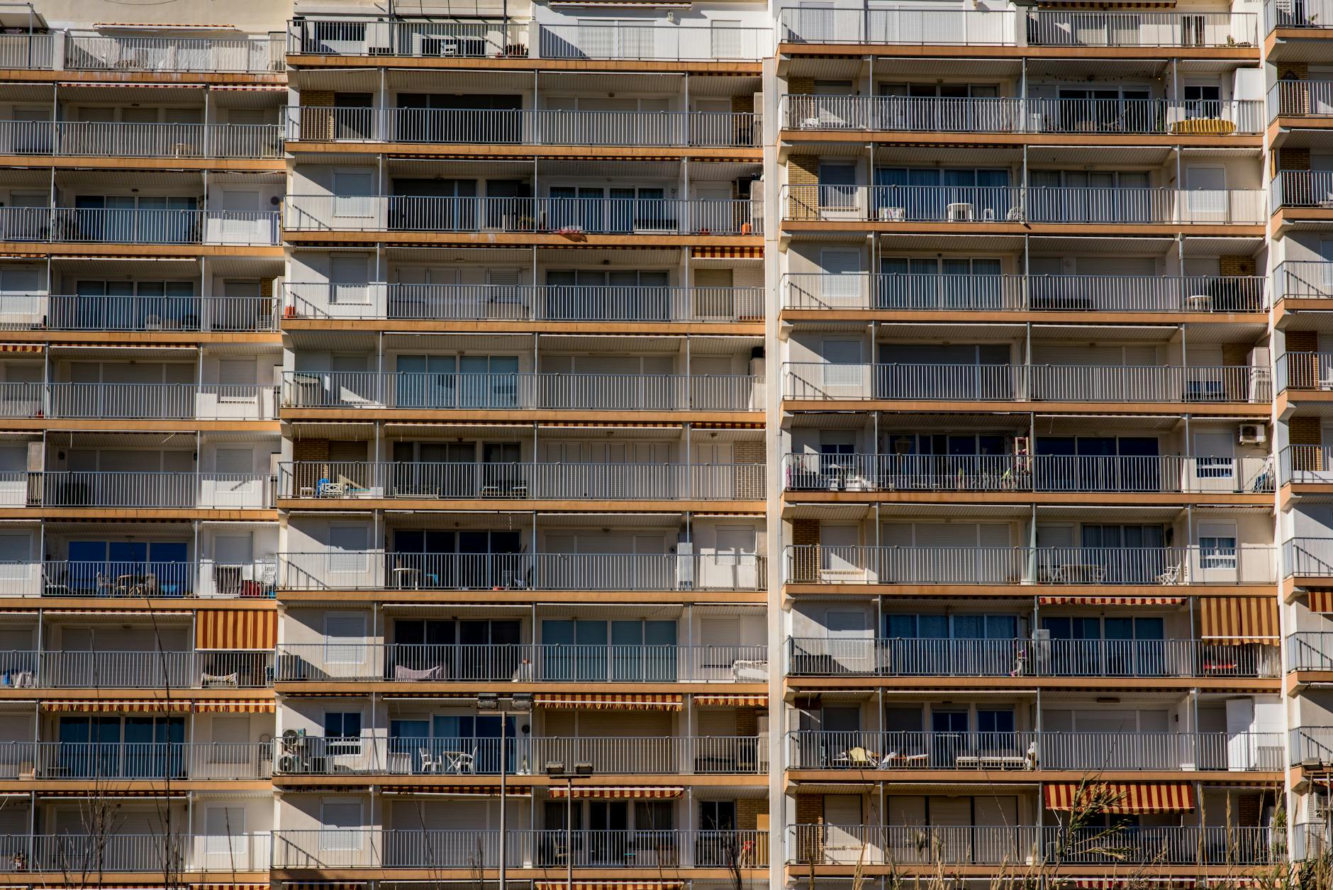 Symmetrical facade of a high-rise apartment building with balconies and windows.