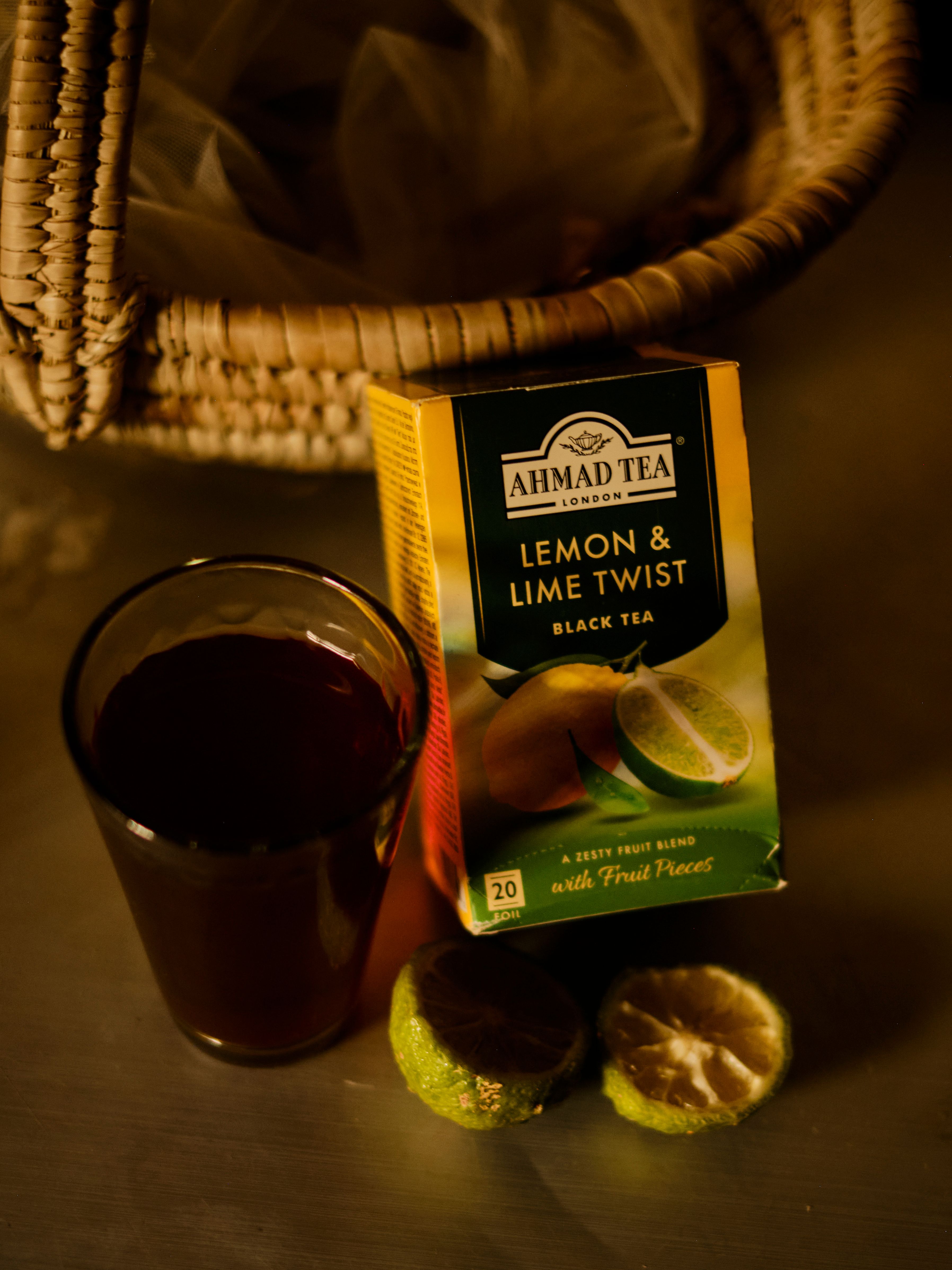 Cozy tea setup with Lemon & Lime Twist tea and fresh limes in warm lighting.