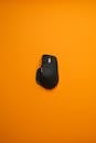 Sleek Black Mouse on Vibrant Orange Background