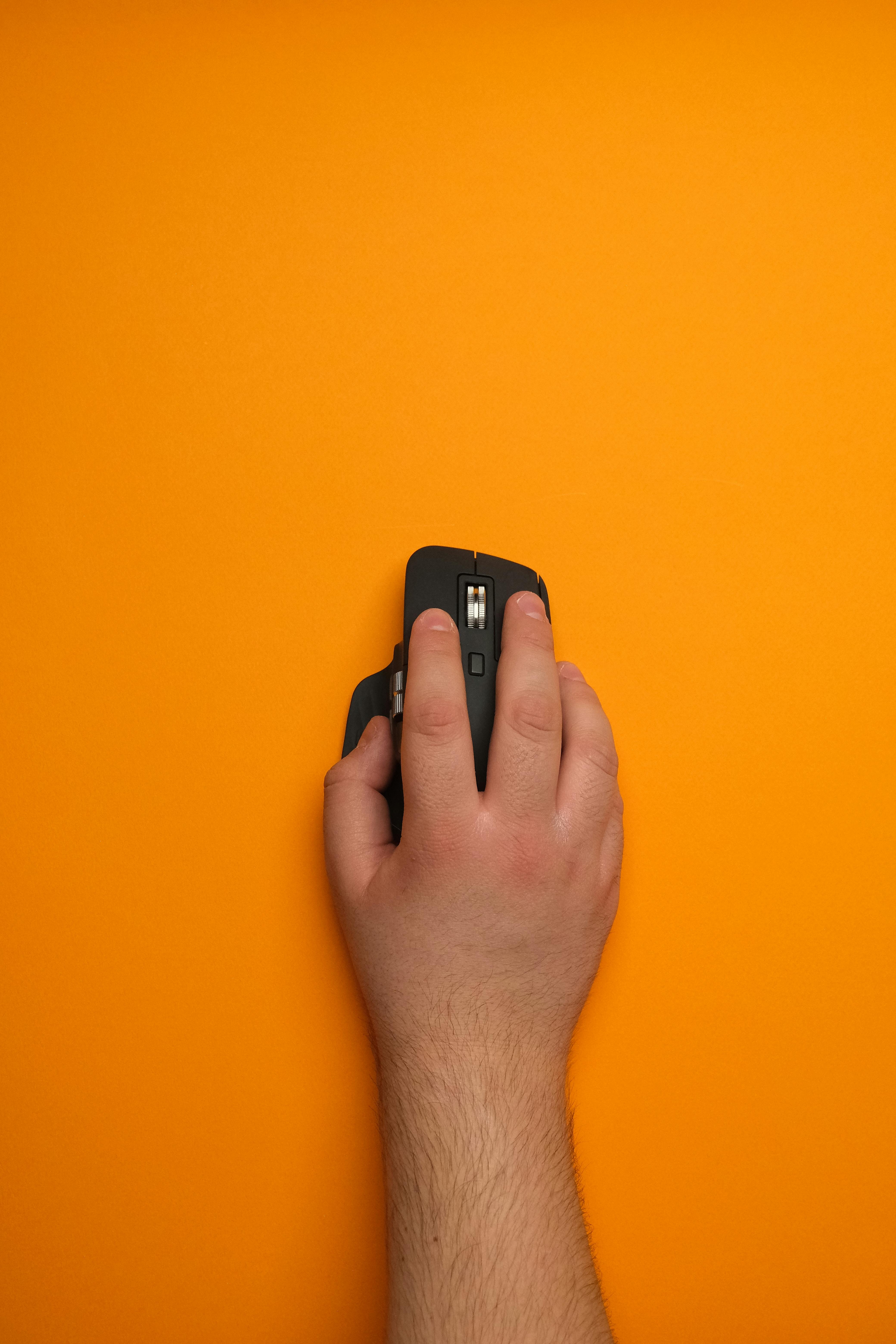 ergonomic wireless mouse on bright orange background