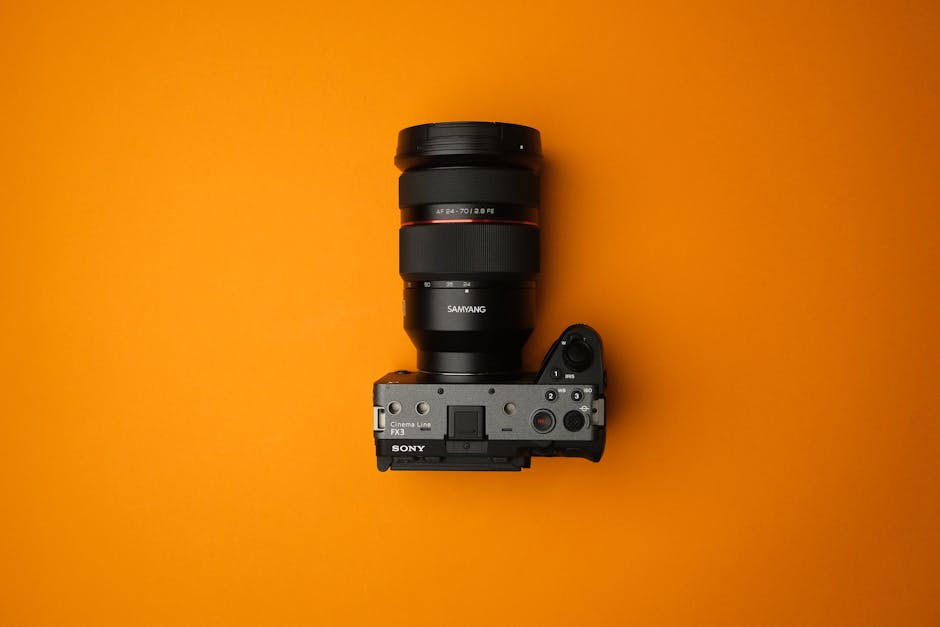 Studio image of a Sony FX3 camera with Samyang lens against a vibrant orange backdrop.