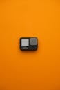 Compact Action Camera on Vibrant Orange Background