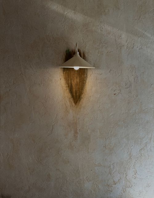 Free A minimalist wall lamp casting a soft glow on a textured surface, creating a serene ambiance. Stock Photo