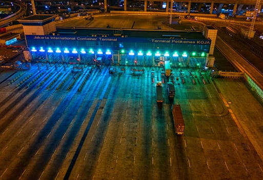 Illuminated aerial view of Jakarta International Container Terminal highlighting logistics activity at night.