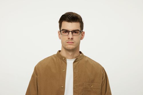 Free Stylish young man wearing glasses in a minimalist fashion portrait. Stock Photo