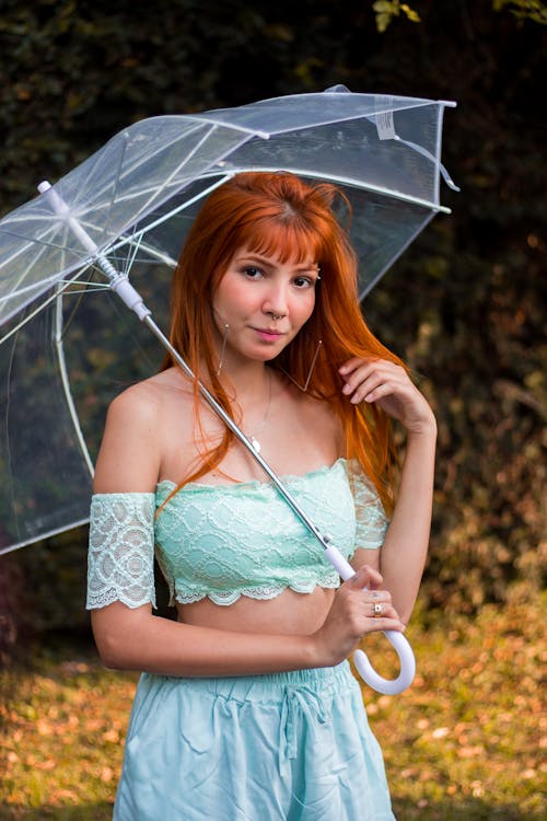 명확한 우산 포즈를 들고 여자의 선택적 초점 사진