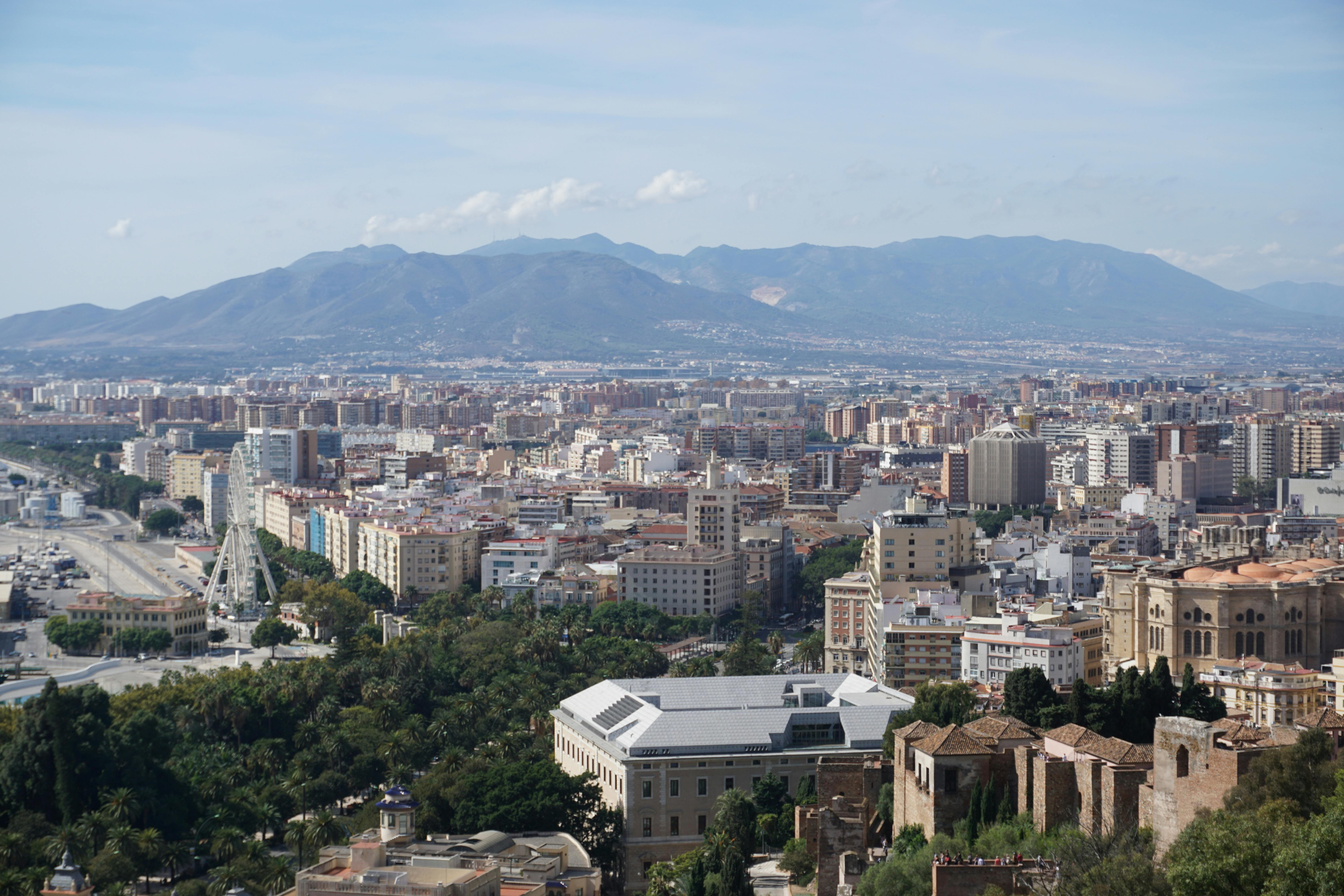 Panoramic view of Malaga cityscape with mountains, capturing architectural details and natural beauty.