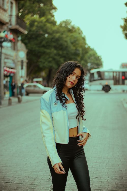 Free Stylish woman in blue jacket posing confidently on a city street. Stock Photo