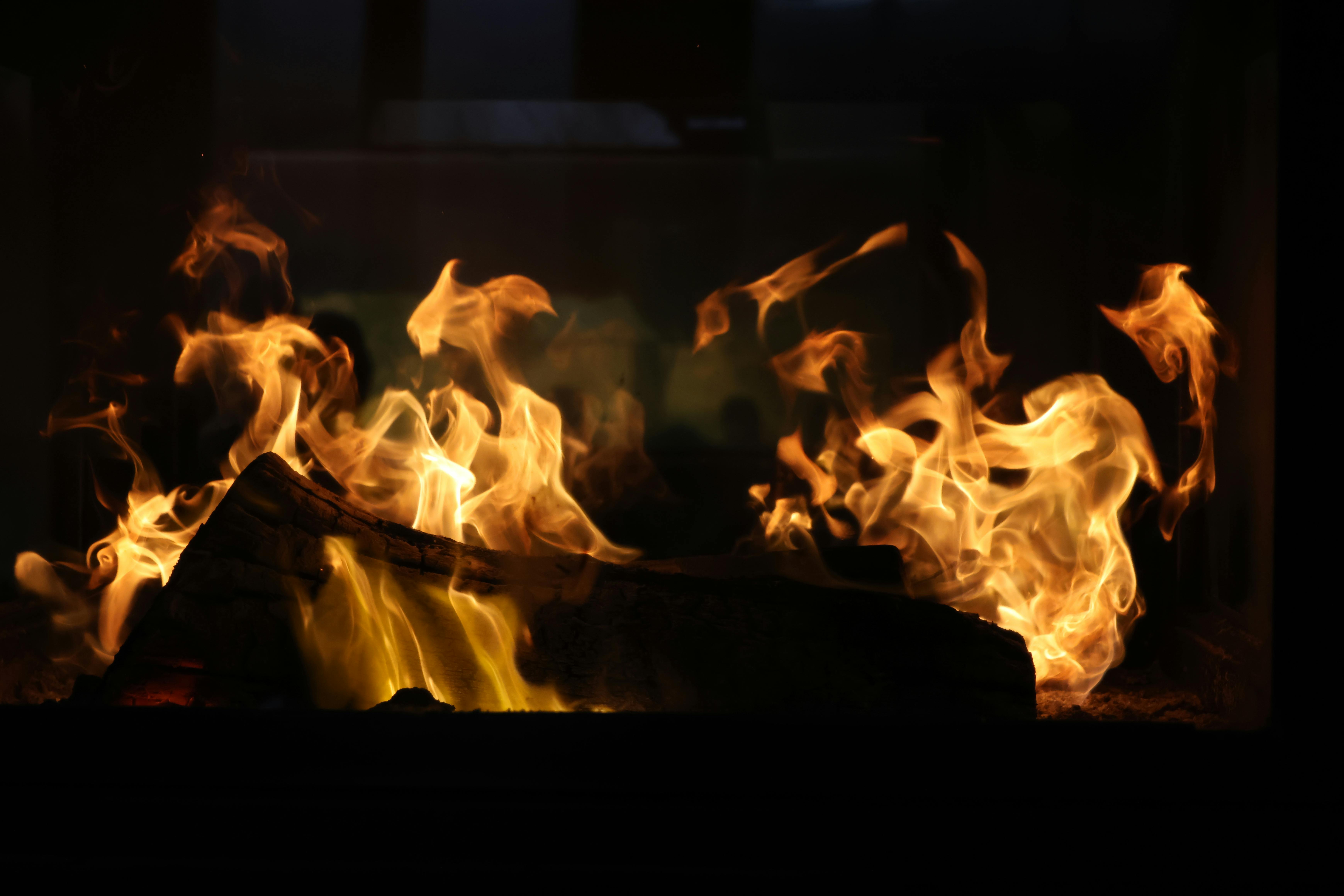 Image captivante de flammes vibrantes dansant dans une cheminée rustique, créant une ambiance chaleureuse.