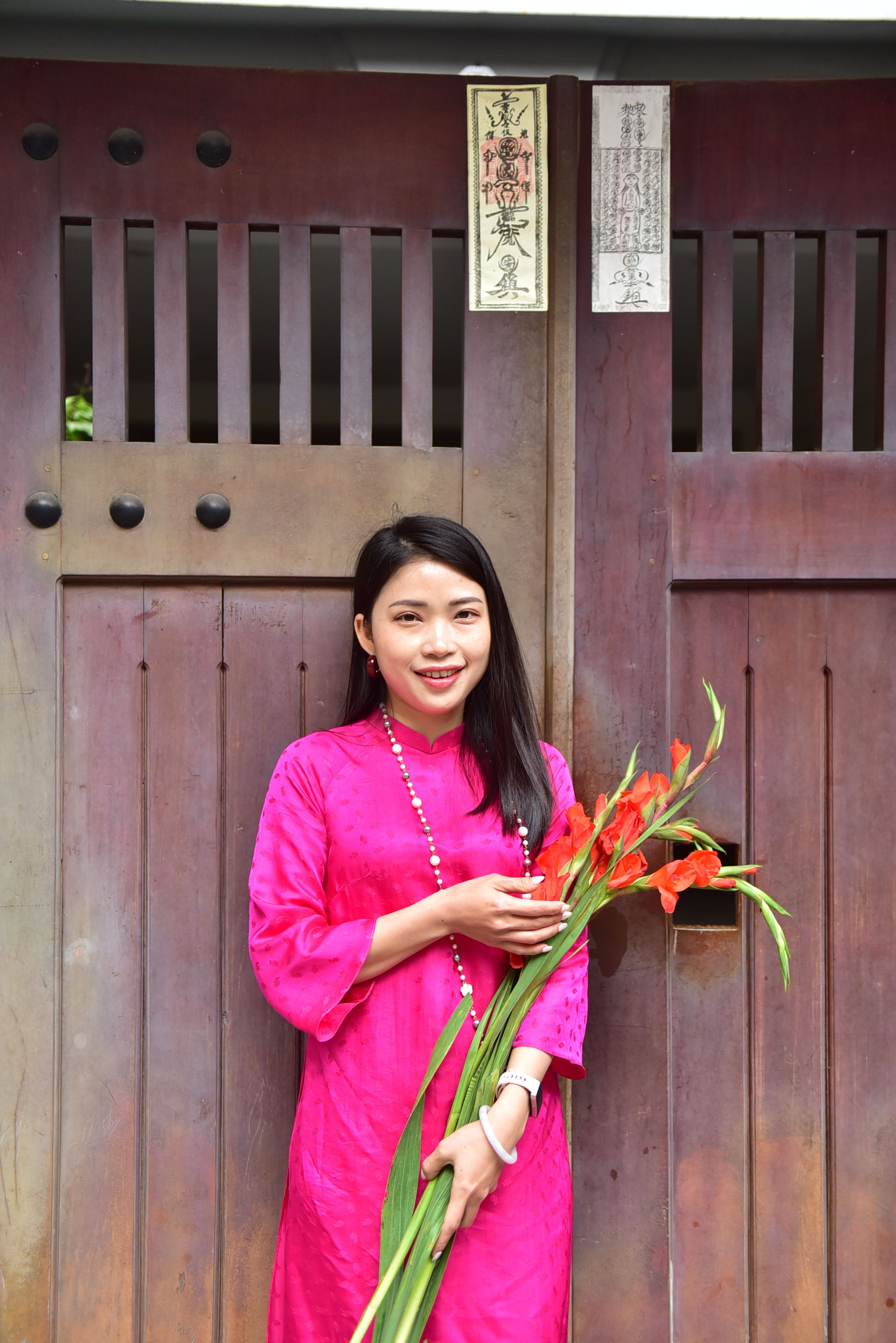Woman in Pink Dress Holding Flowers by Wooden Gate · Free Stock Photo