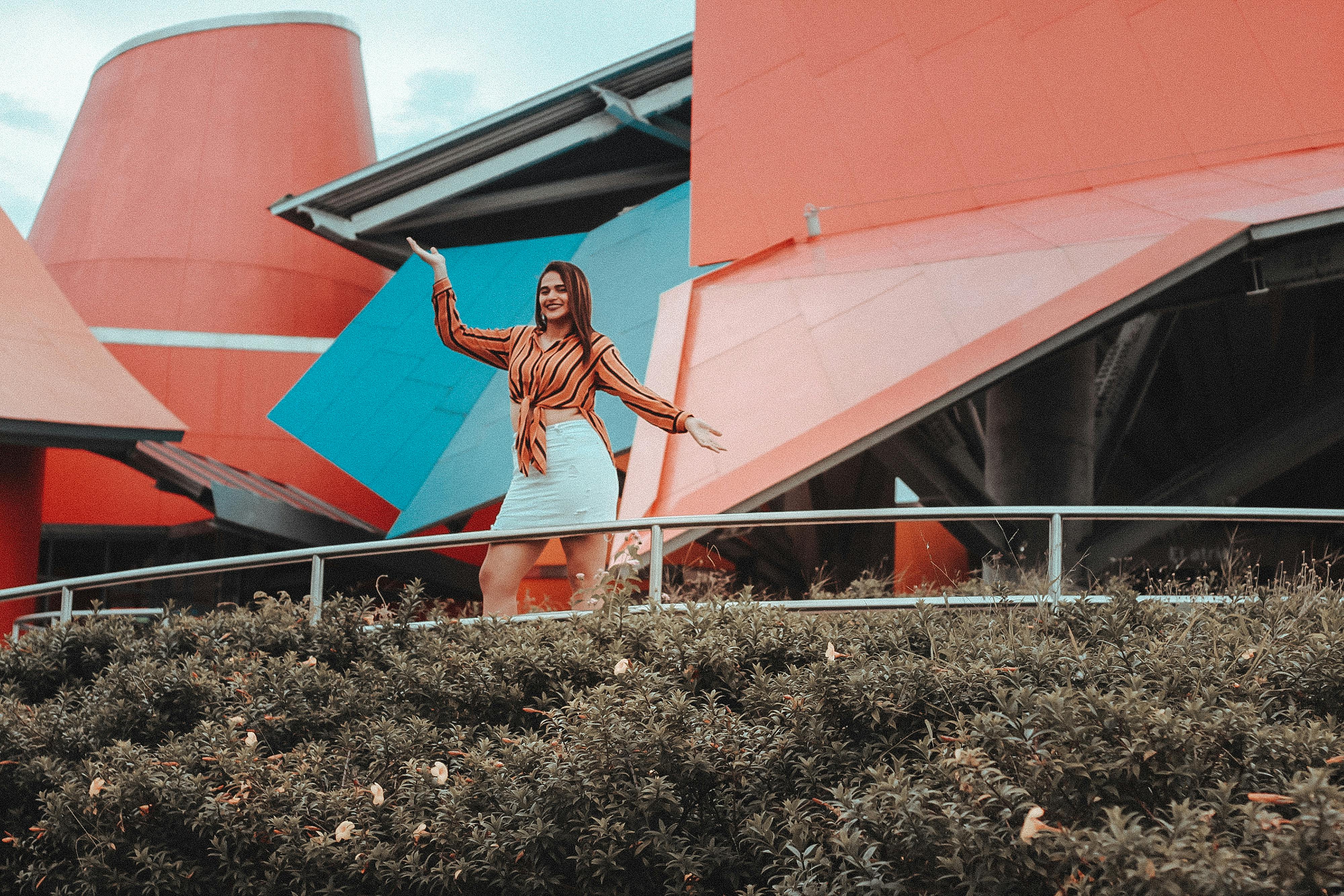 年轻女子在充满活力的现代建筑前摆姿势