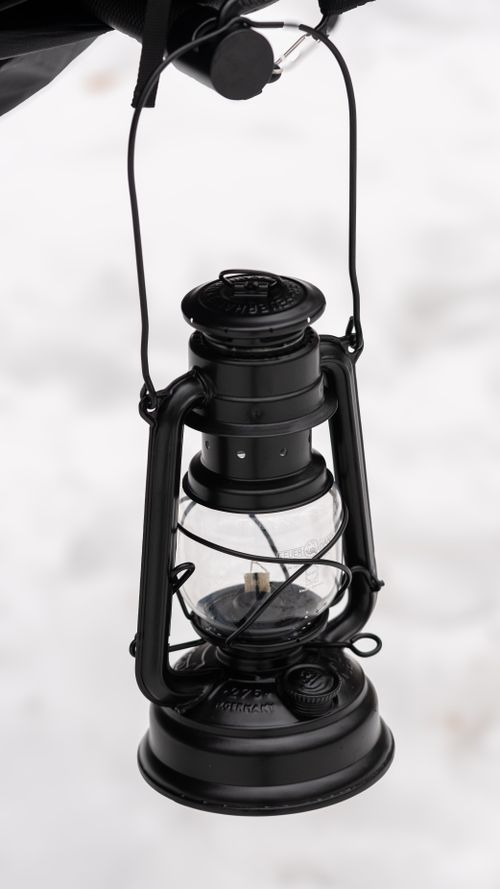 Free A vintage black lantern hanging outdoors against a snowy backdrop in Bolu, Türkiye. Stock Photo