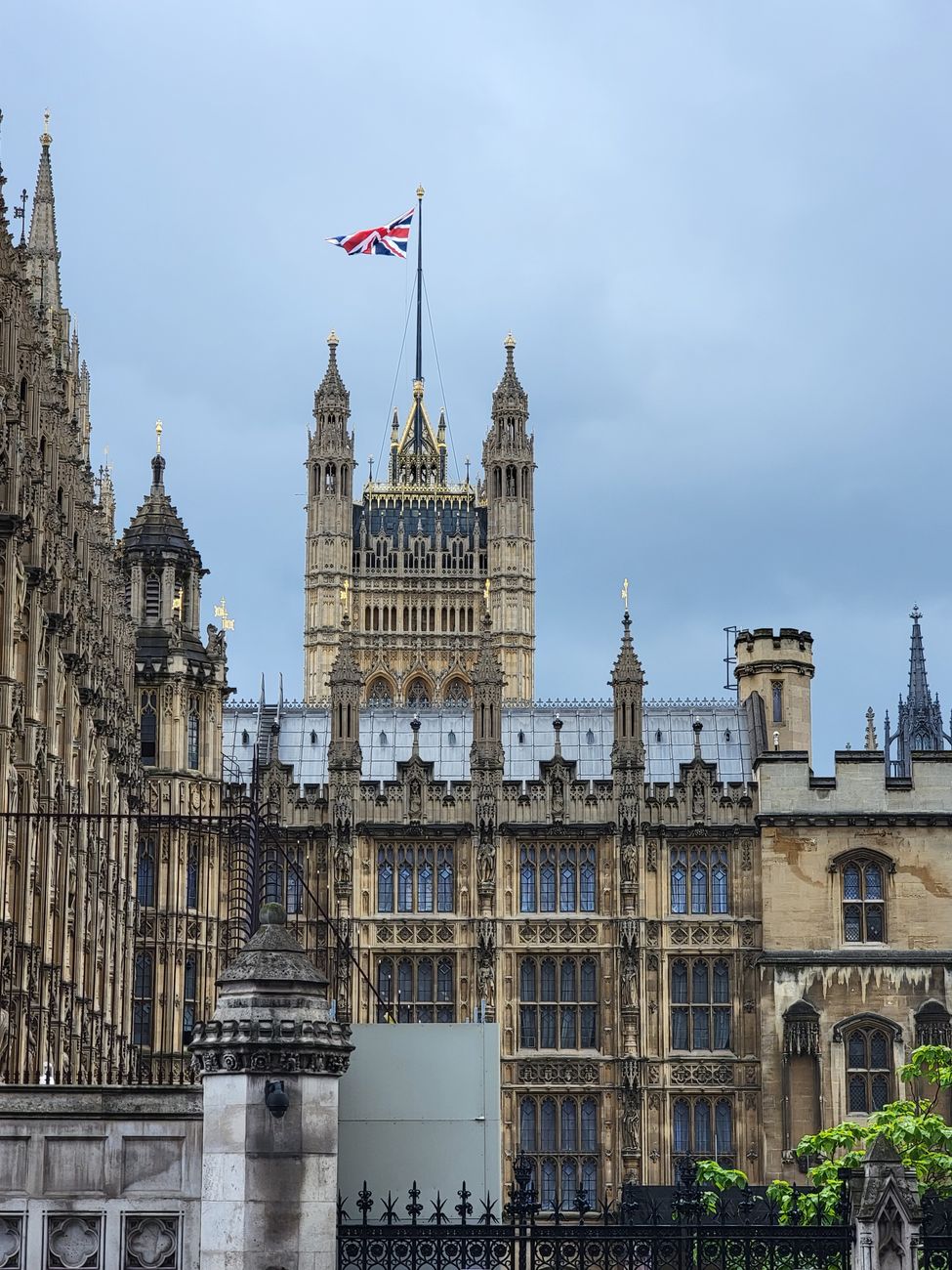 Iconisch uitzicht op het Britse parlementsgebouw met de Union Jack in de lucht.