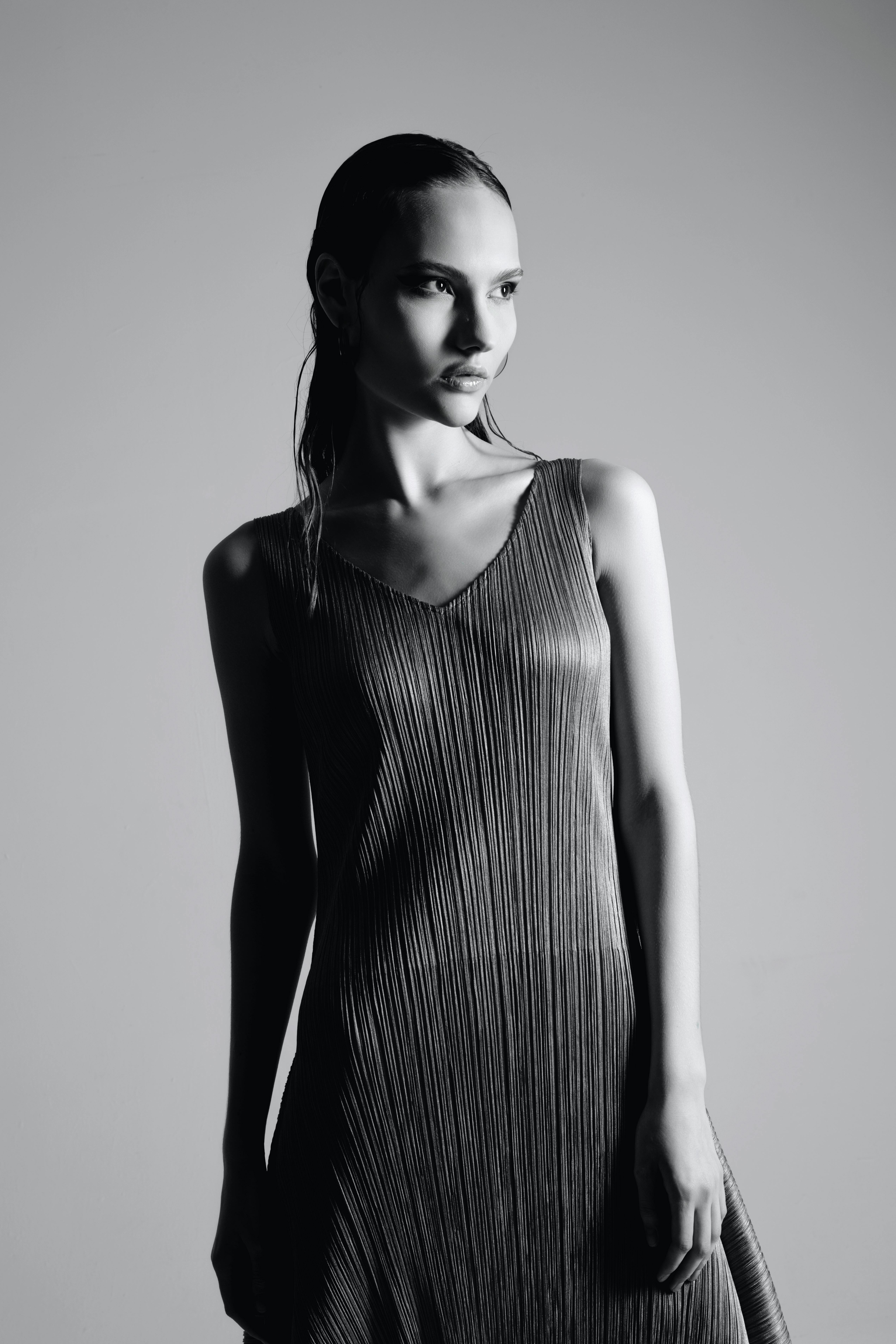 Elegant black and white portrait of a female model in a textured dress.