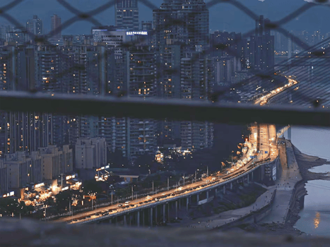 A stunning nighttime cityscape highlighting a bustling highway beneath towering skyscrapers.