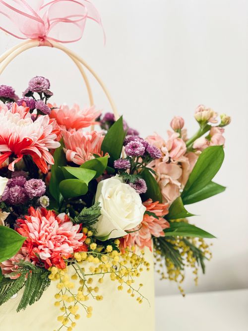 Free Beautiful pastel floral arrangement featuring rose, chrysanthemum, and more in a delicate basket. Stock Photo