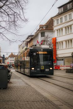 A tram travels through a historic European city street, showcasing urban life.