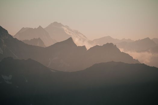 Captivating view of the Alpine mountains shrouded in mist at dawn, showcasing serene natural beauty.