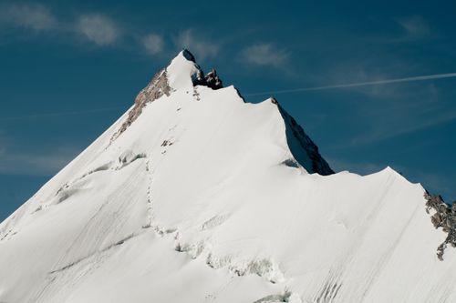 Free Stunning snow-covered alpine mountain peak against a clear blue sky, showcasing natural beauty. Stock Photo