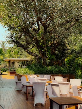 Serene outdoor cafe surrounded by lush greenery in GA, India, perfect for relaxation.
