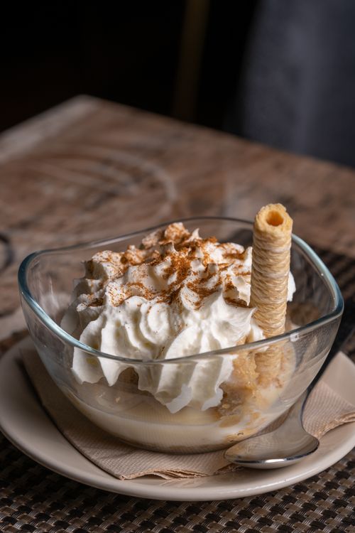 Free A delicious dessert topped with whipped cream and a wafer stick in a glass bowl. Stock Photo
