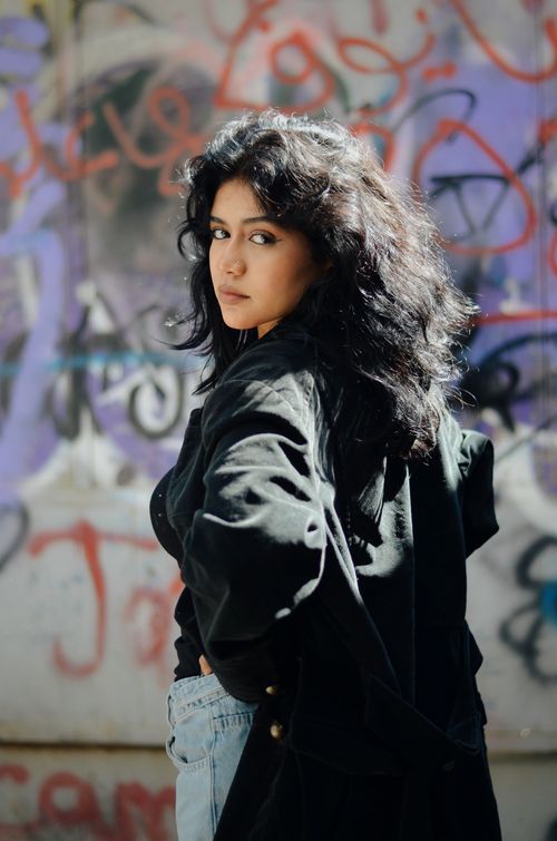 Free Fashionable woman posing against colorful graffiti wall in Cairo, Egypt. Stock Photo