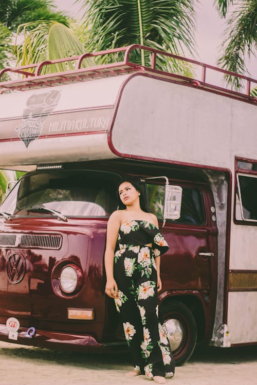 Woman In Floral Wear While Leaning on A Vehicle