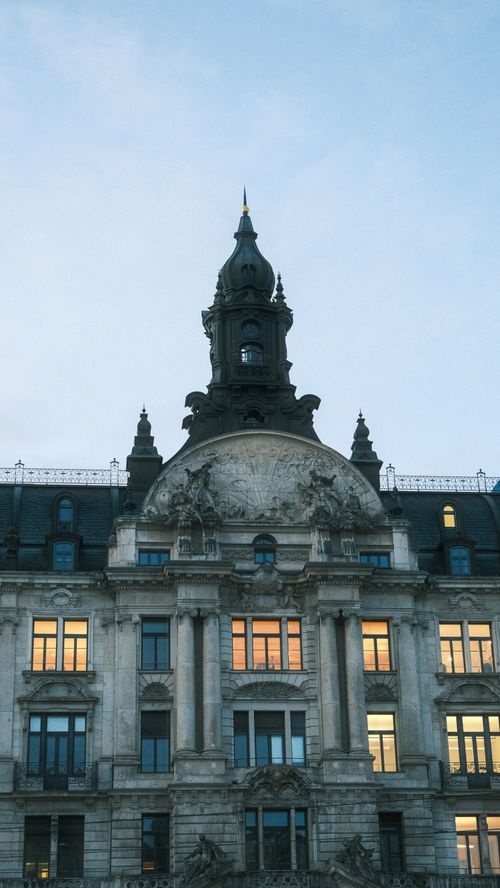 Free A historic building with intricate architecture at dusk, capturing warm reflections. Stock Photo