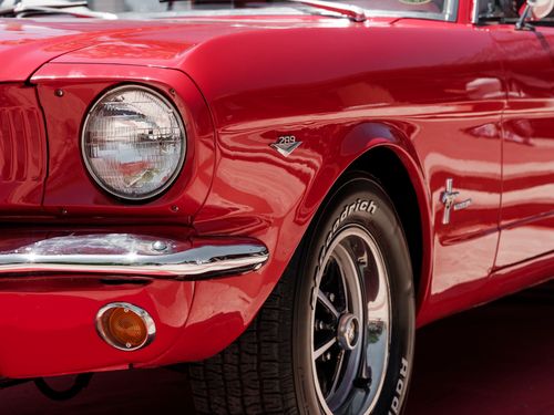 Free Detailed shot of a classic red vintage car highlighting the front design and headlight. Stock Photo