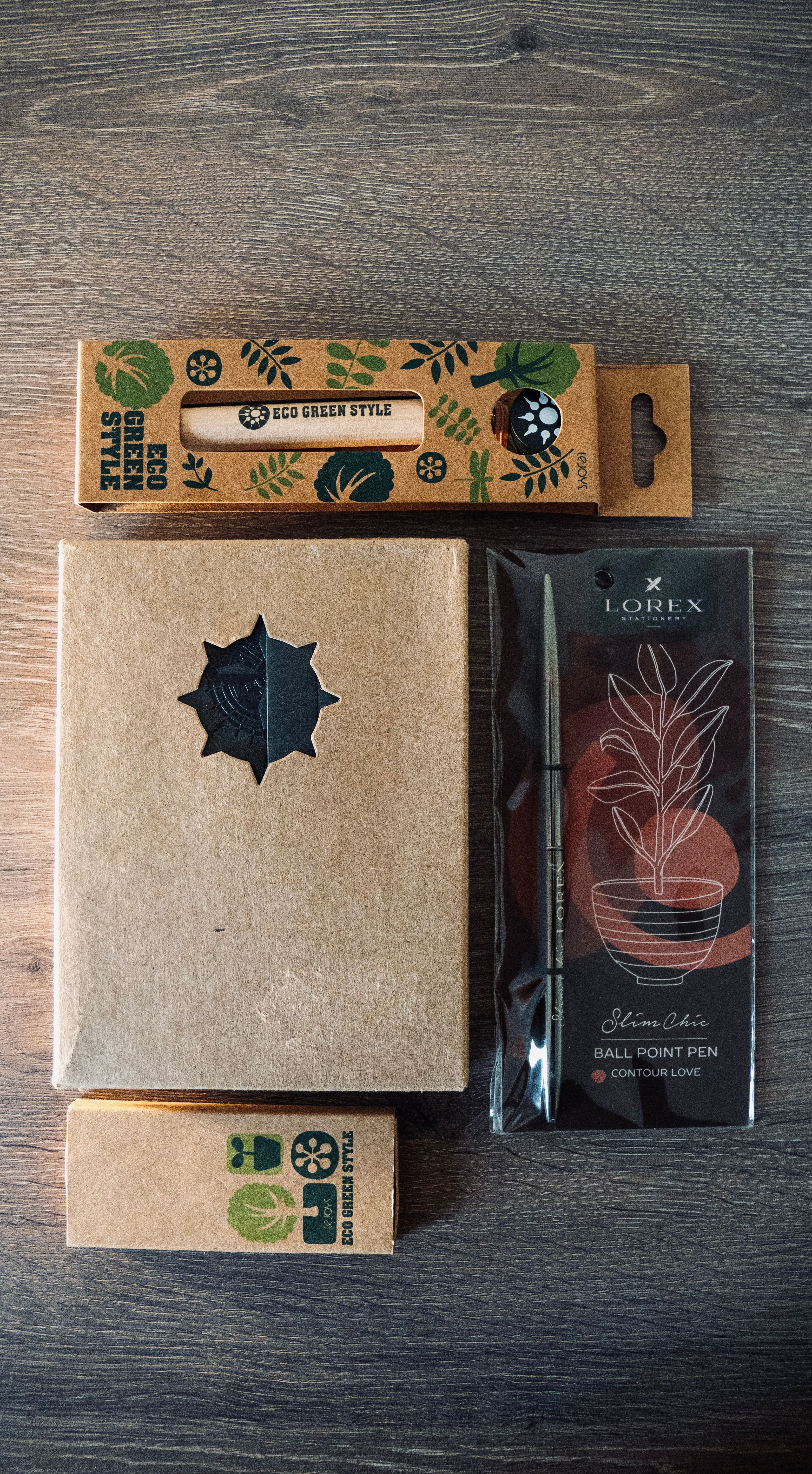Top view of eco-friendly stationery items packaged on a wooden table.