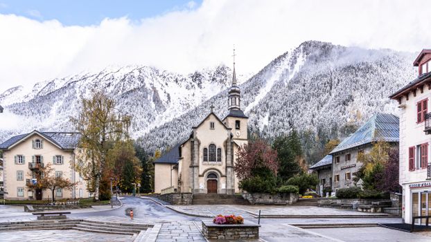 Picturesque view of Chamonix's church and snowy Alps, capturing the town's charming ambiance.