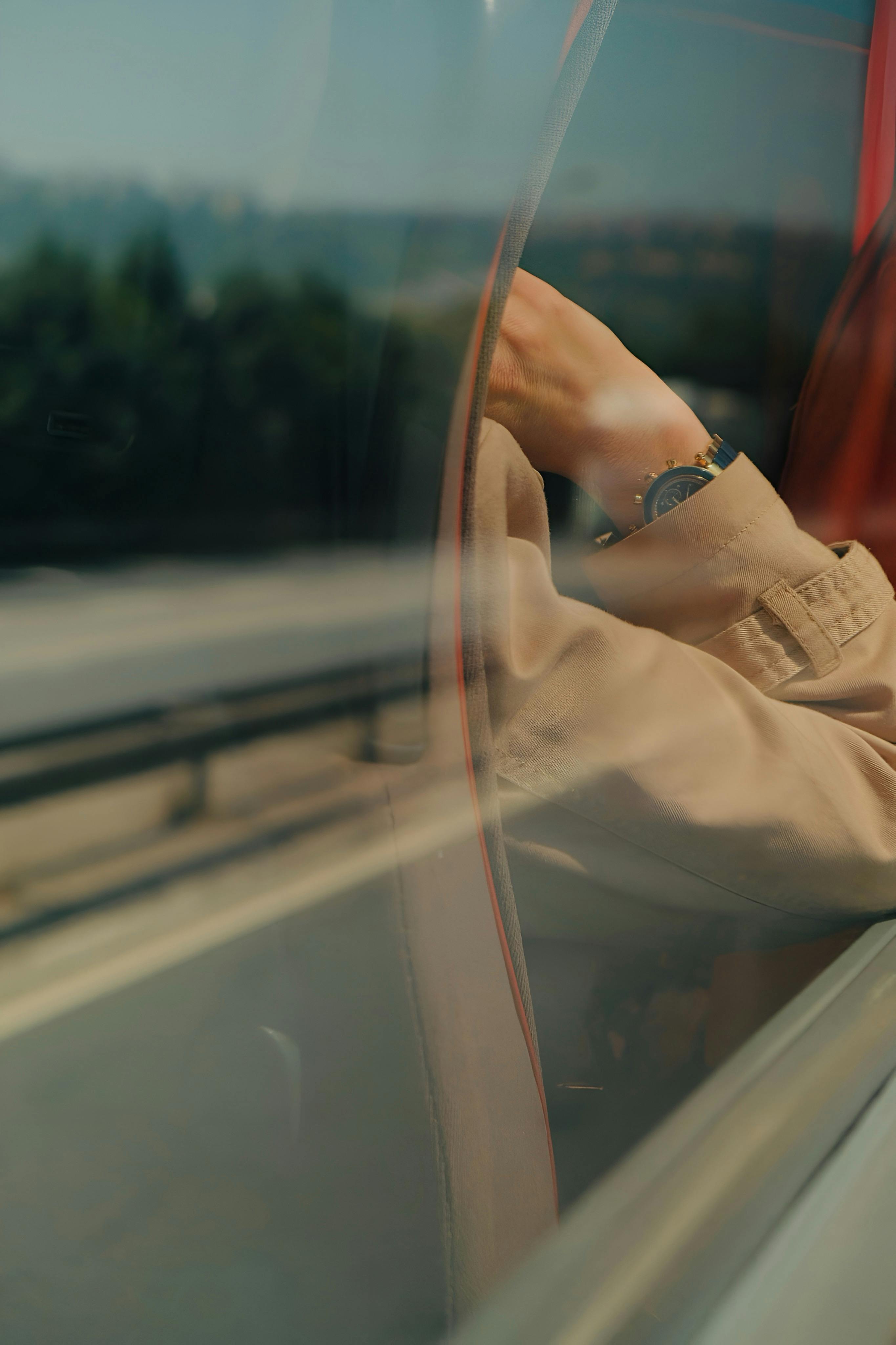 A serene look outside a train window capturing a calm road view.